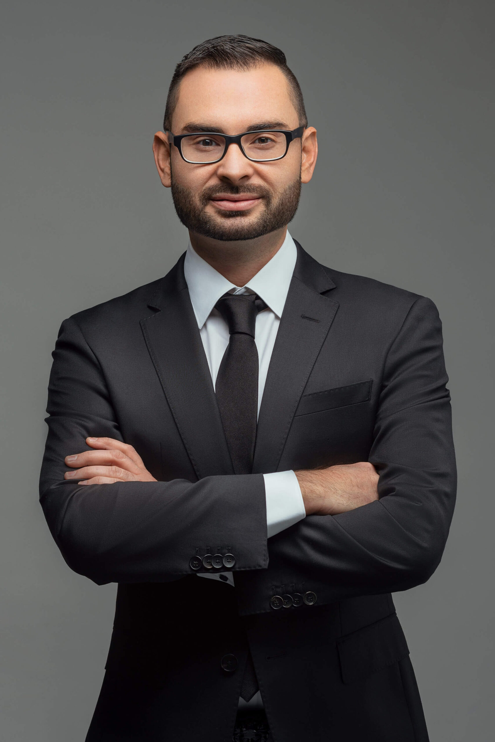 Professional headshot of a man in business attire, exuding confidence and professionalism.